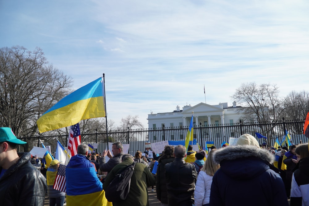 a crowd of people standing in front of the white house