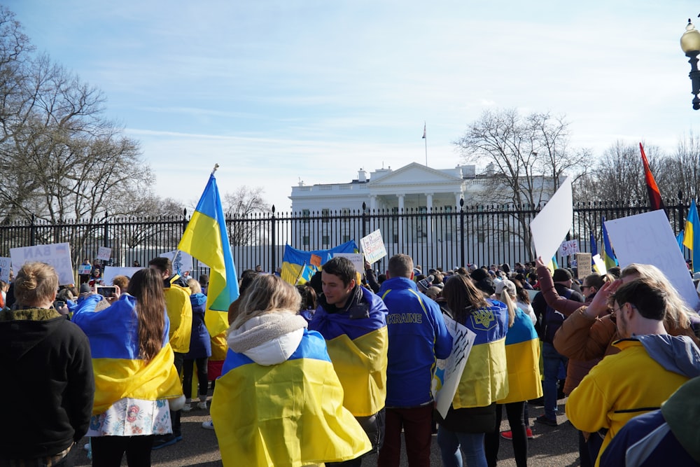 a group of people standing around each other holding flags