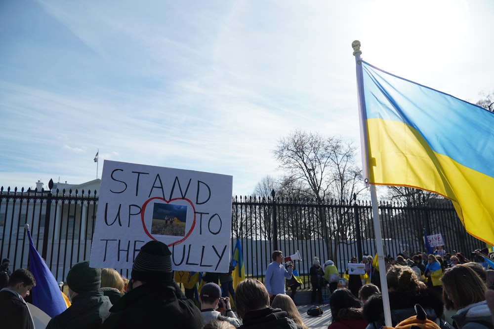 a crowd of people holding signs and flags