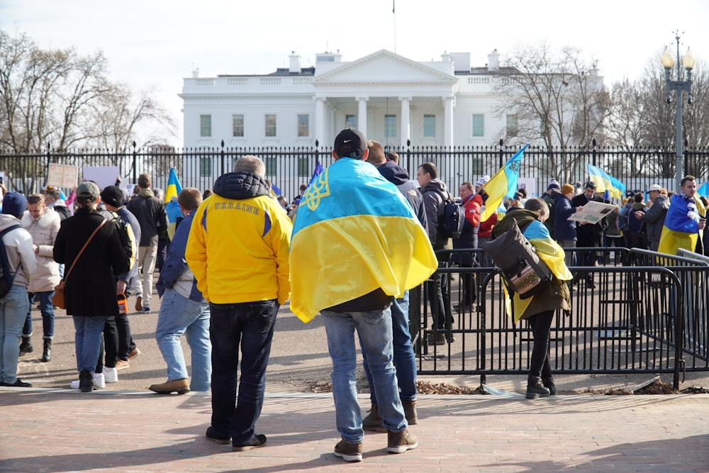 a group of people standing in front of a fence