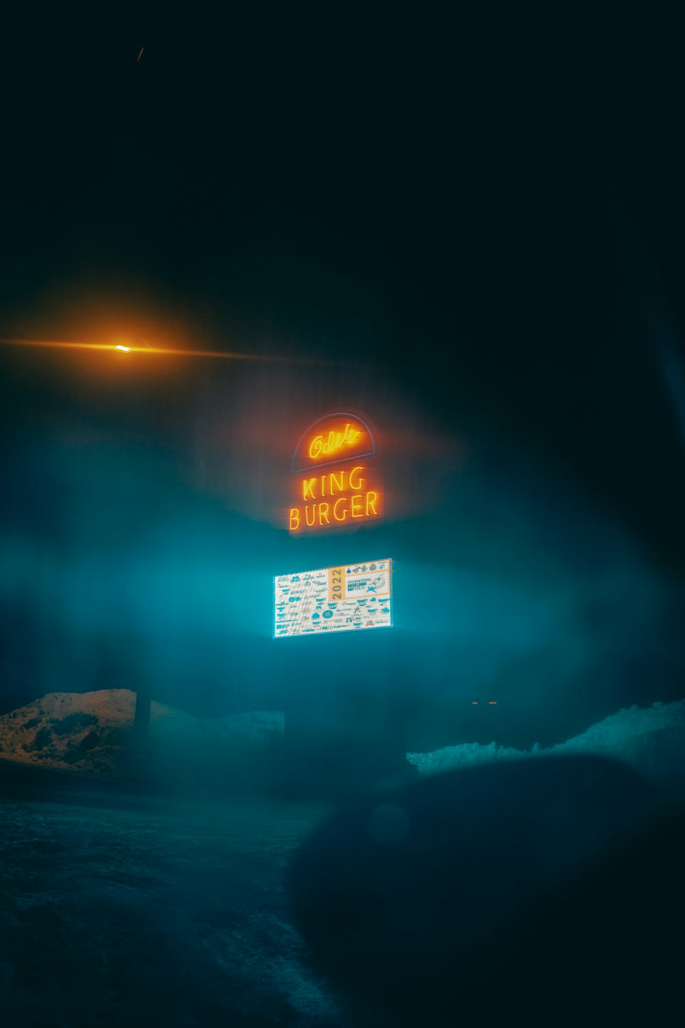a neon sign in the middle of a dark sky