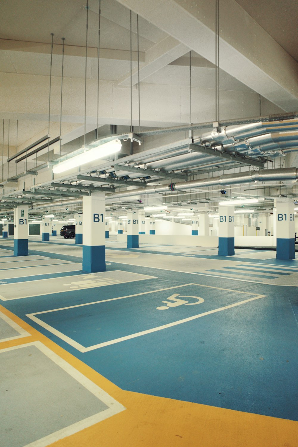 an empty parking garage with blue and yellow flooring