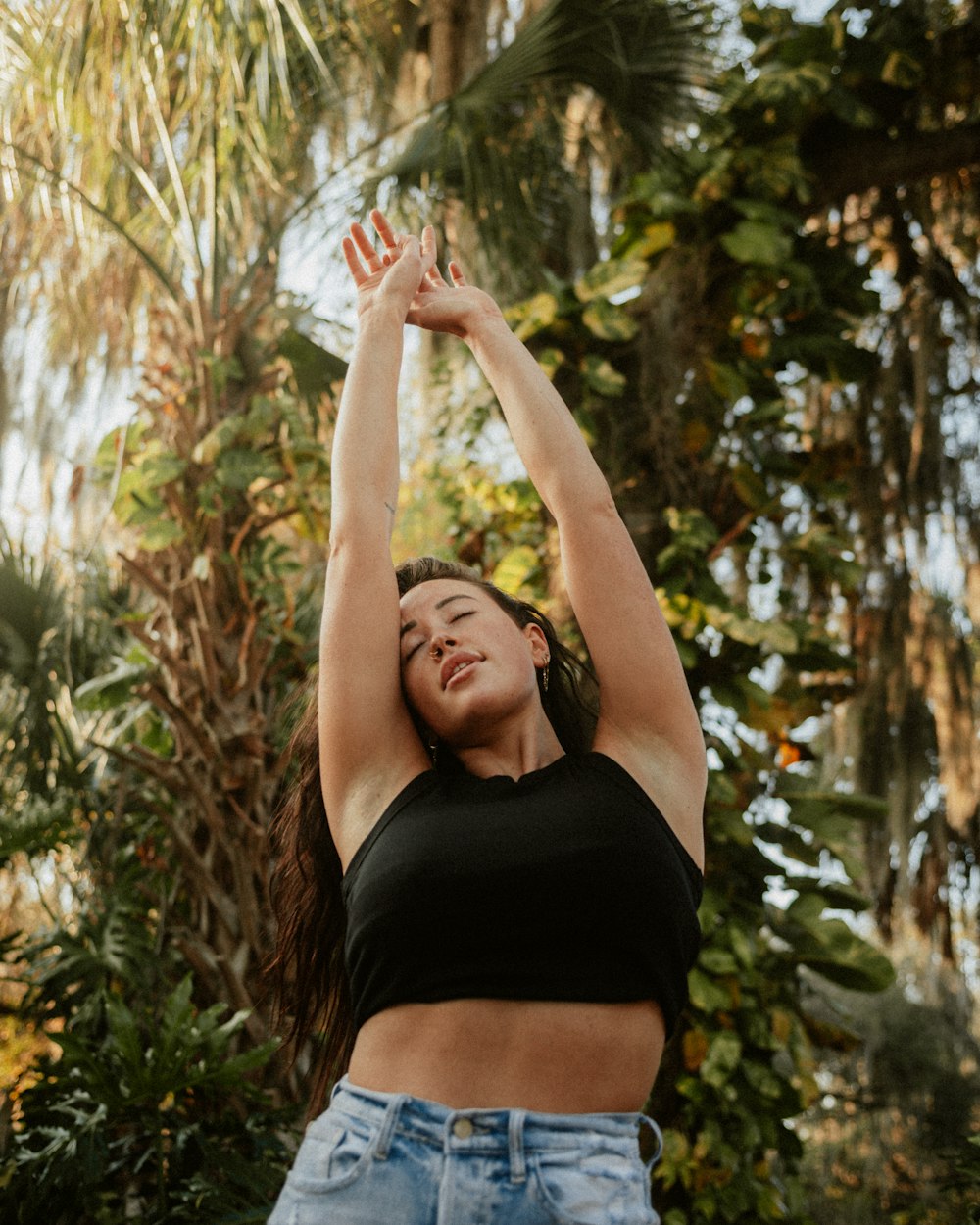 a woman reaching up to reach a frisbee