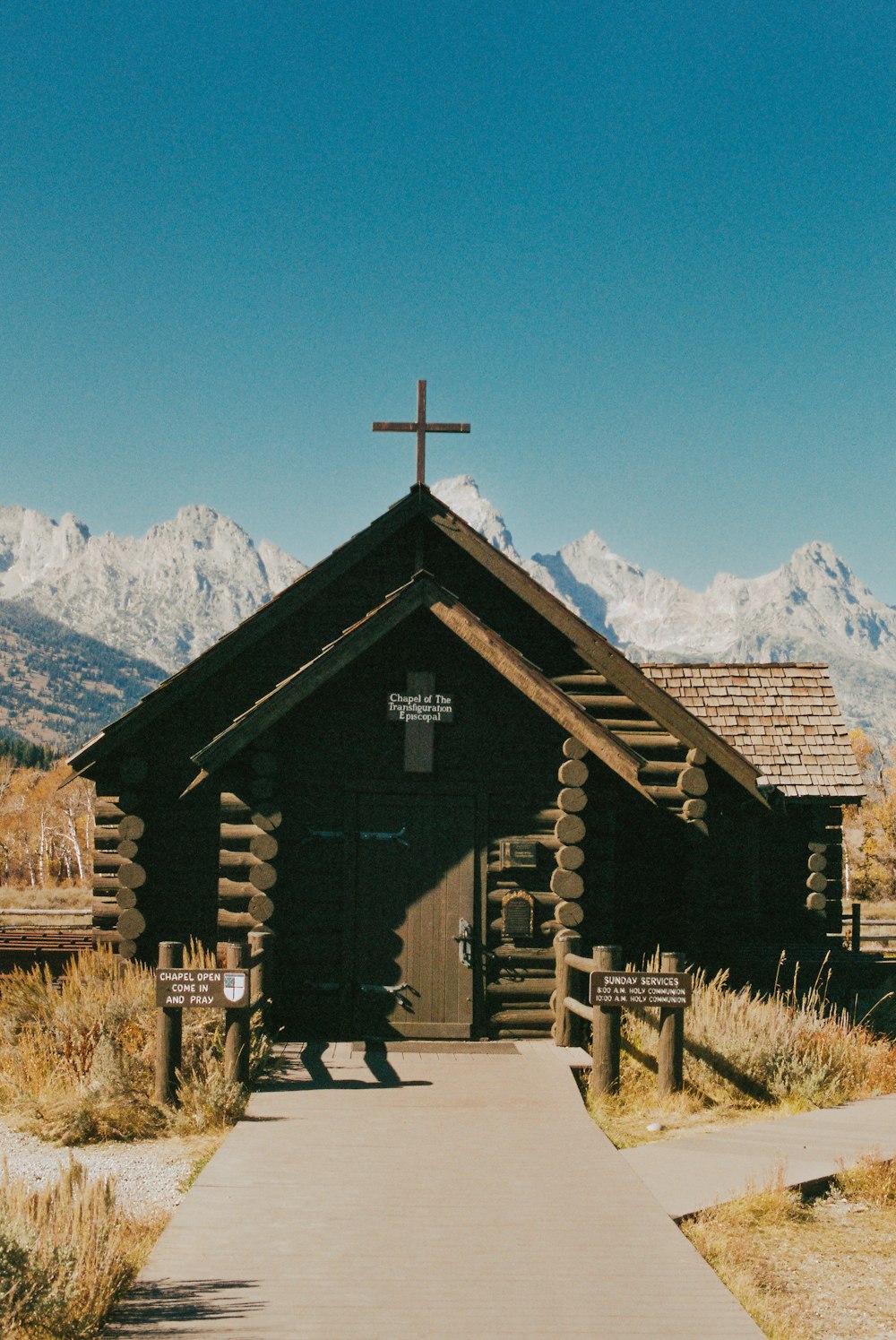 a wooden church with a cross on top of it