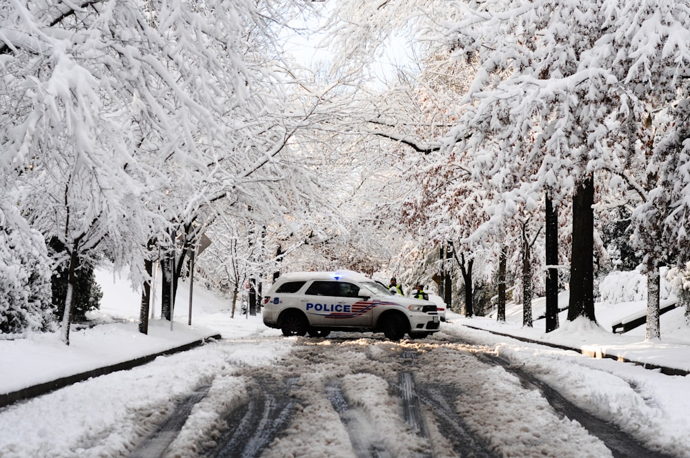 a police car driving down a snowy road