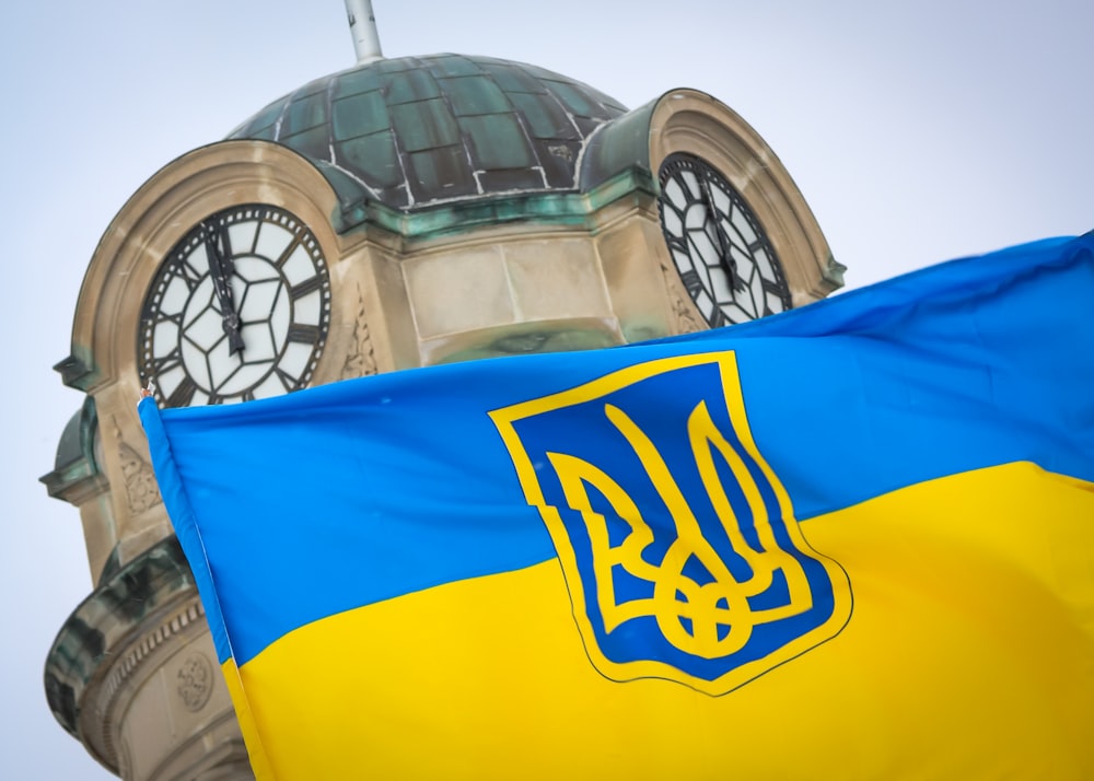 a flag with a clock tower in the background