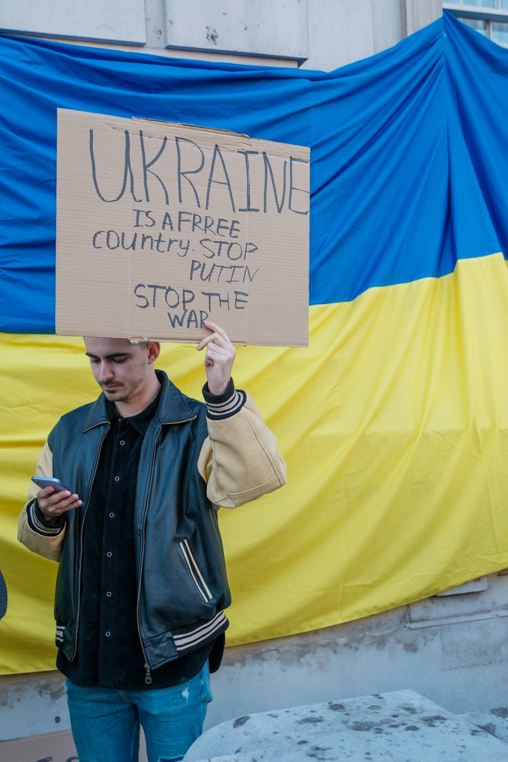 a man holding a sign that reads ukraine