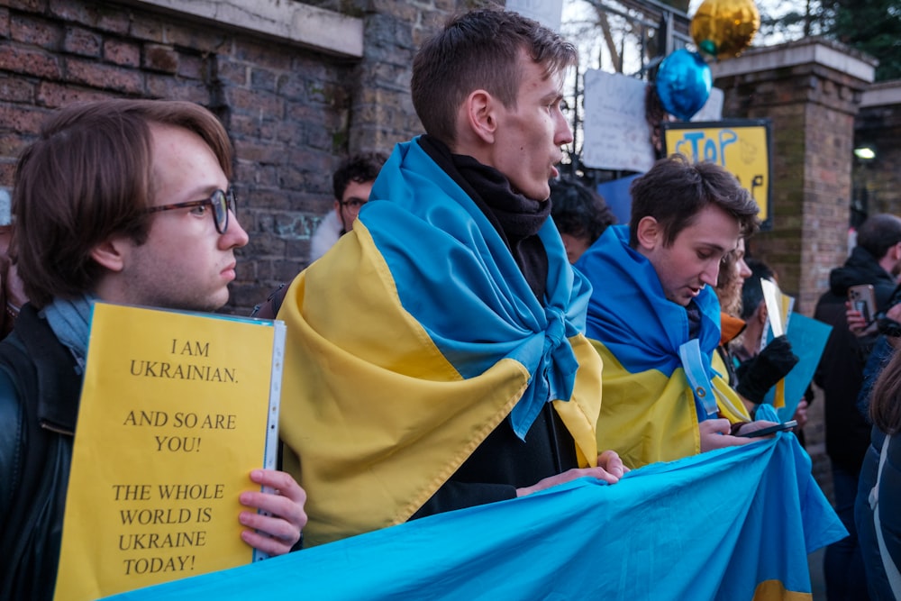 a group of people standing around each other holding signs