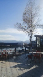 A serene café terrace bathed in soft golden light, overlooking a quiet street in a charming overseas city.