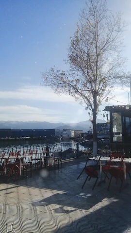A serene café terrace bathed in soft golden light, overlooking a quiet street in a charming overseas city.