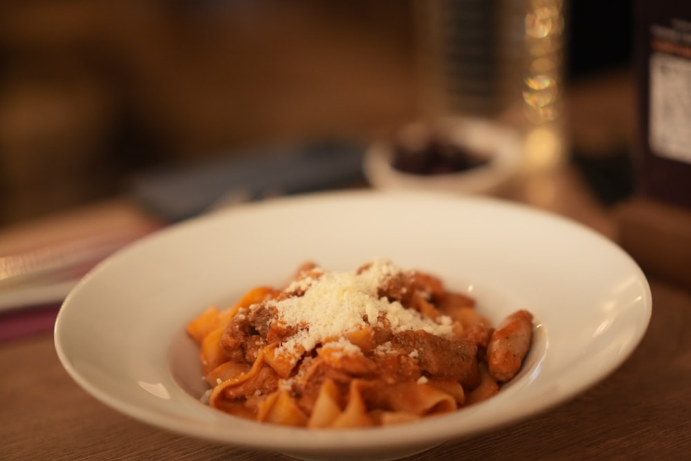 a white bowl filled with pasta and sauce