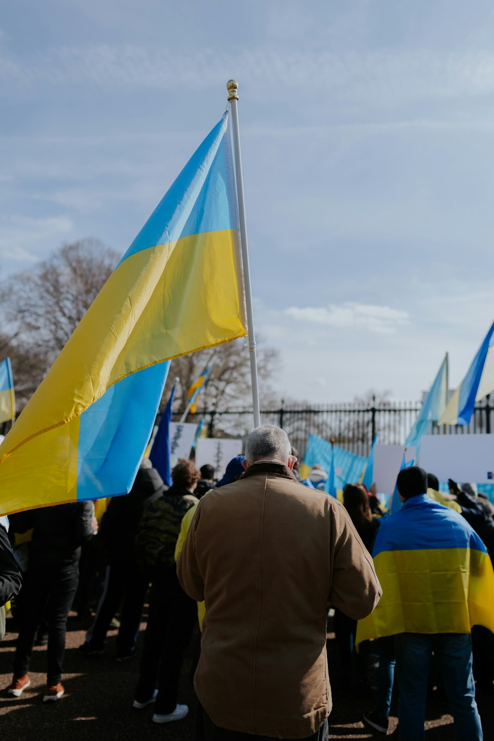 un groupe de personnes debout les unes à côté des autres tenant des drapeaux