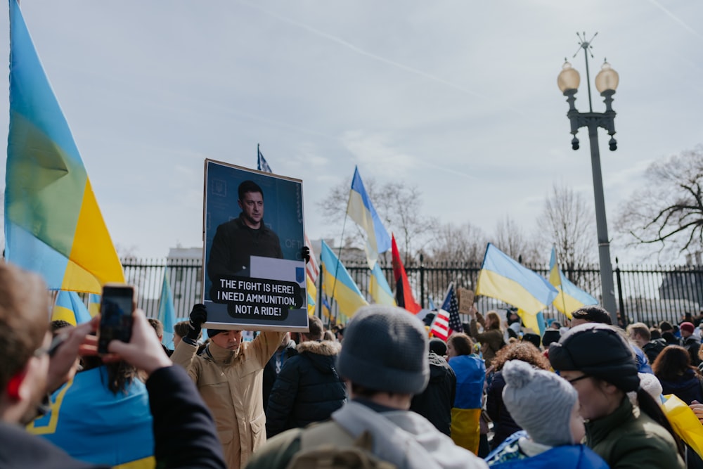 a crowd of people holding signs and flags