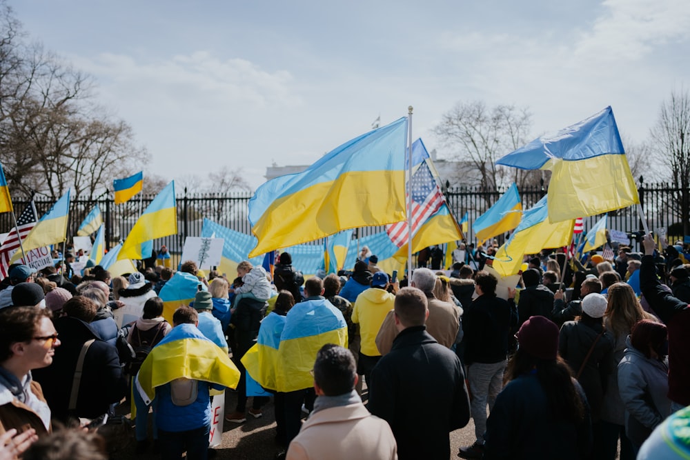 a large group of people holding flags and signs