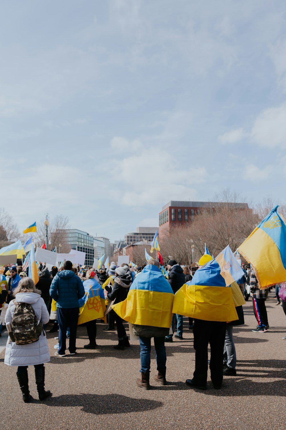 a group of people holding flags and wearing rain coats