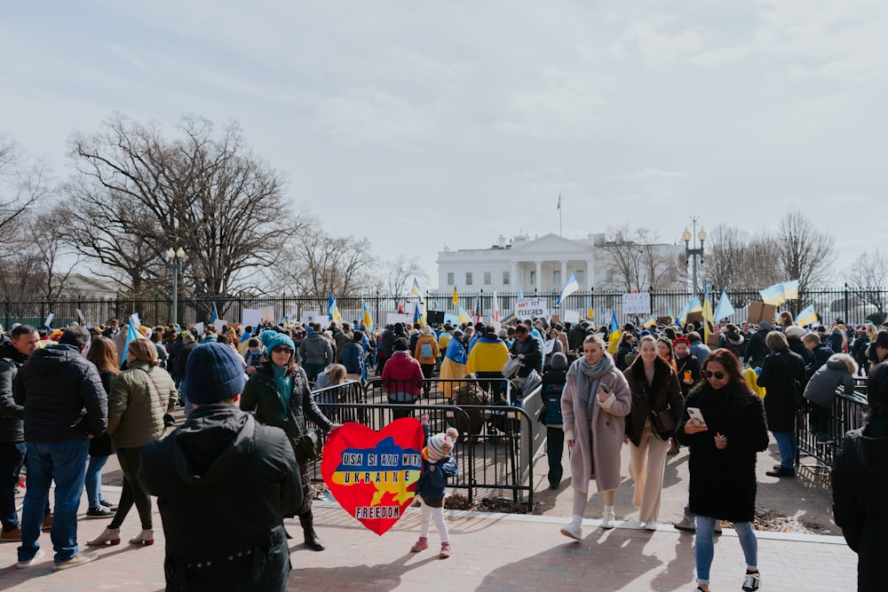 a crowd of people standing around a fence