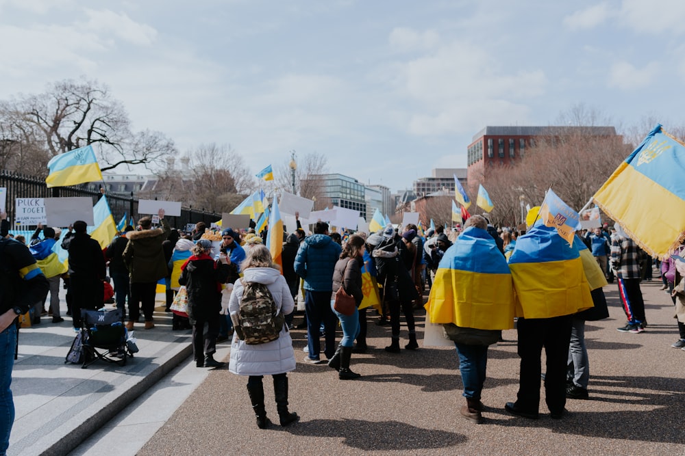 Un groupe de personnes marchant dans une rue avec des drapeaux