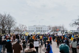 A group of passionate volunteers holding 'America First' signs at a lively outdoor press conference in Florida.