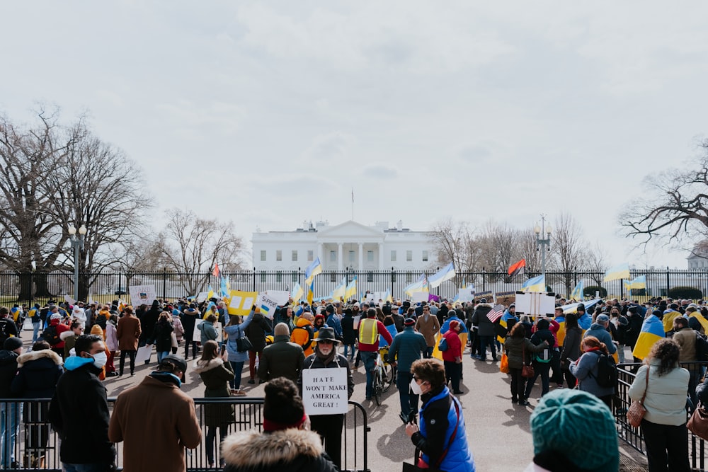 a large crowd of people standing in front of the white house