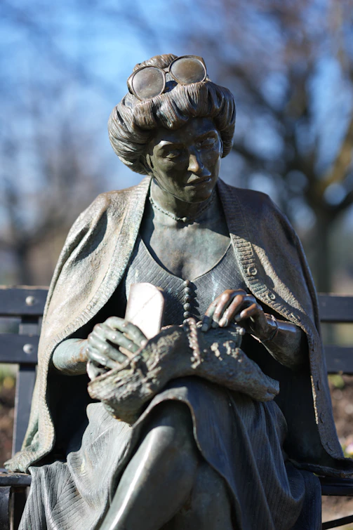 a statue of a woman sitting on a bench