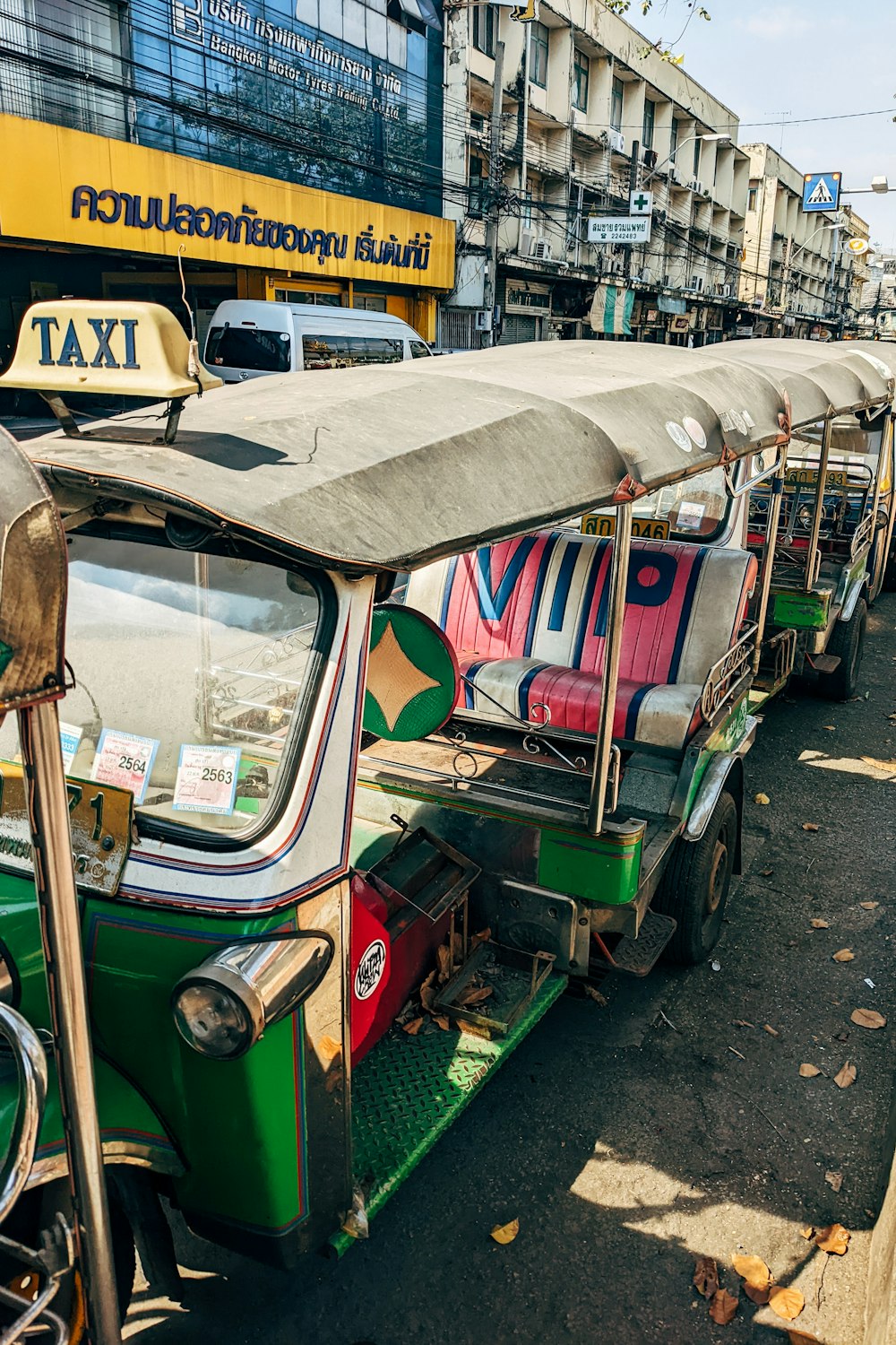 a row of colorfully painted rickshaws parked on the side of the road