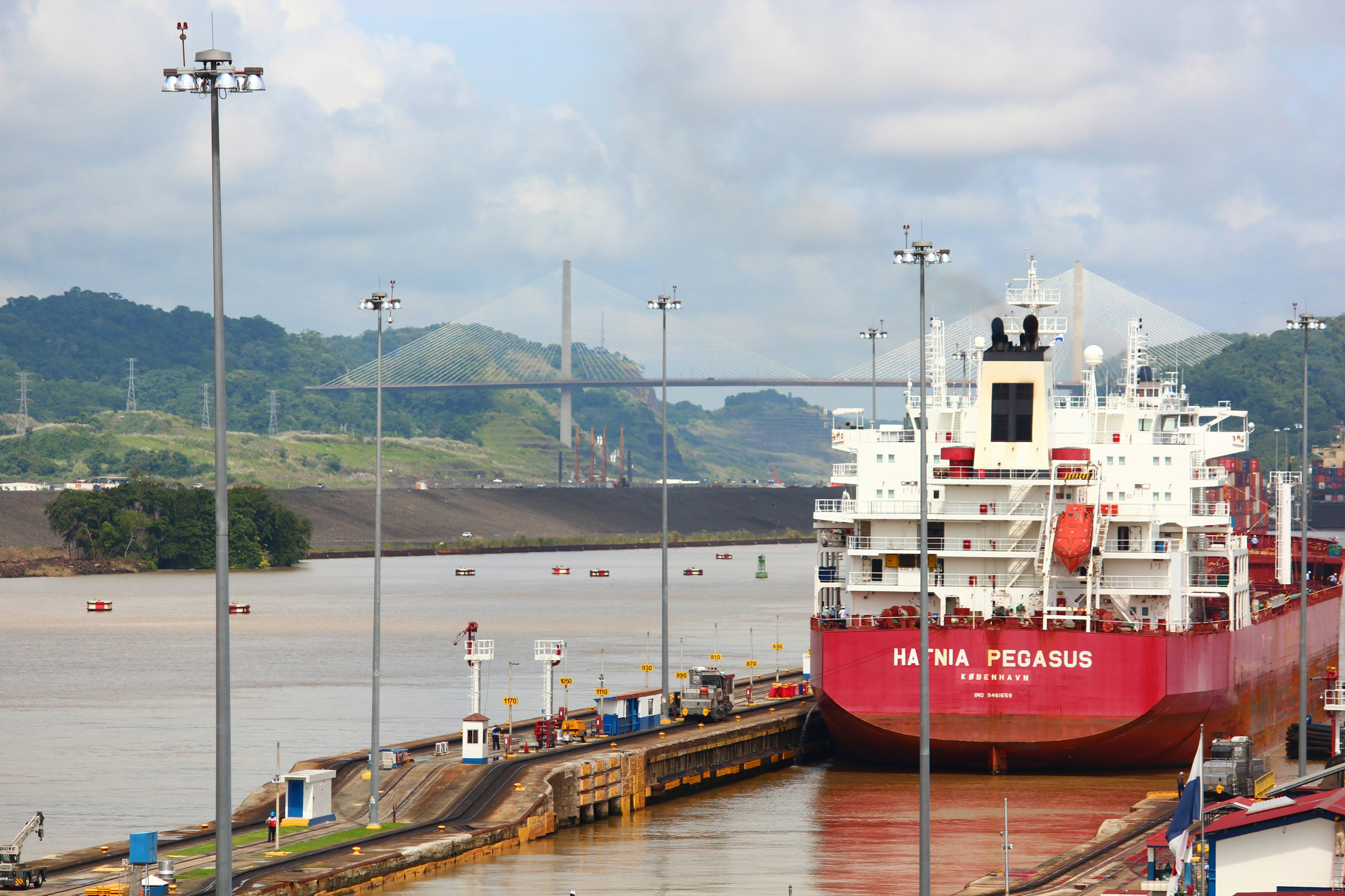 a large red and white boat docked at a dock, Ship crossing in Panama