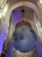 A serene chapel interior illuminated by soft golden light with lunar motifs.