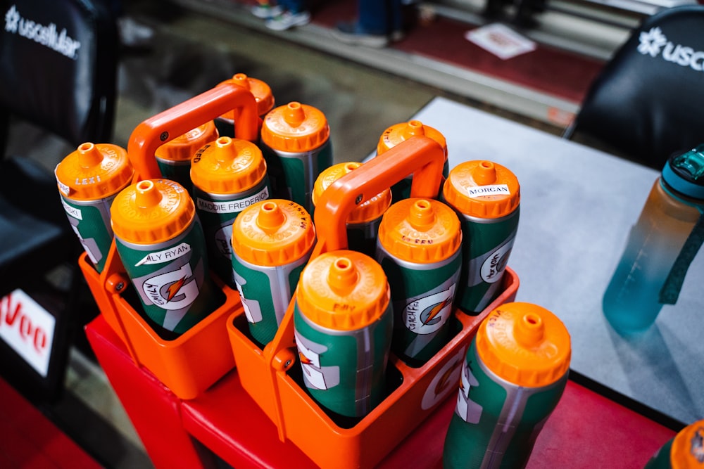 a bunch of orange and green cans sitting on top of a red table