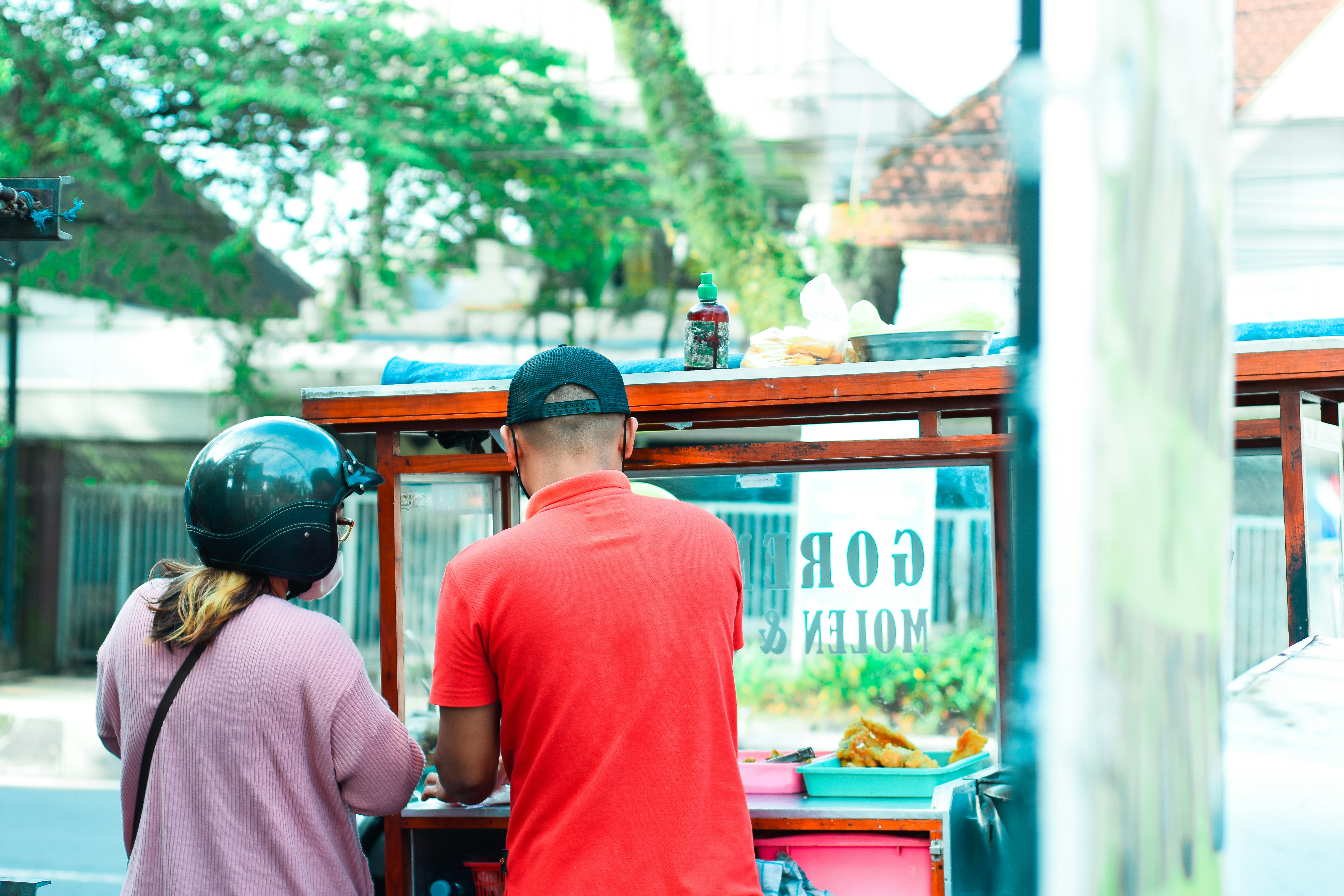 seorang pria dan seorang wanita berdiri di gerobak makanan