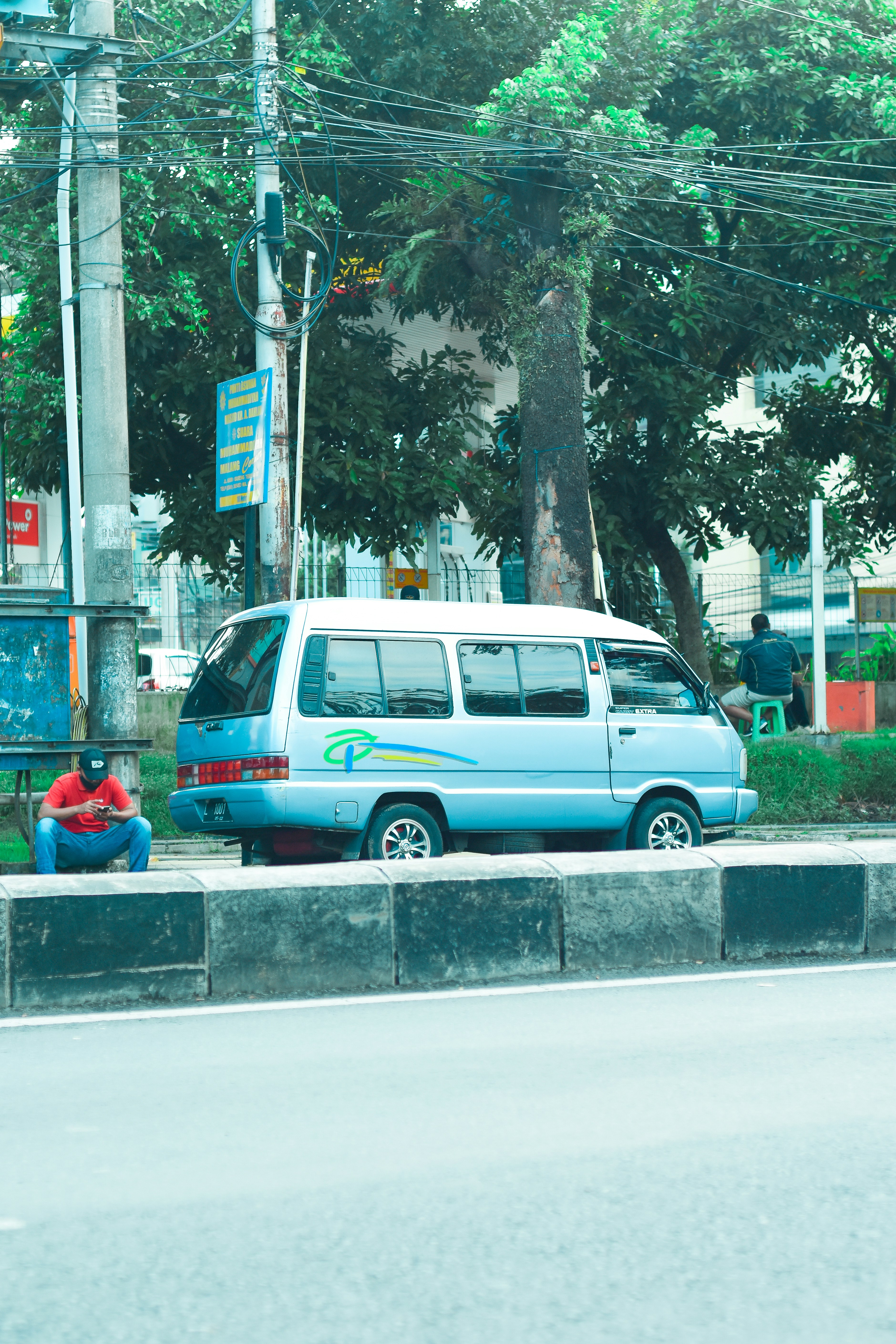 A blue van parked on the side of a road photo – Free Person Image on ...