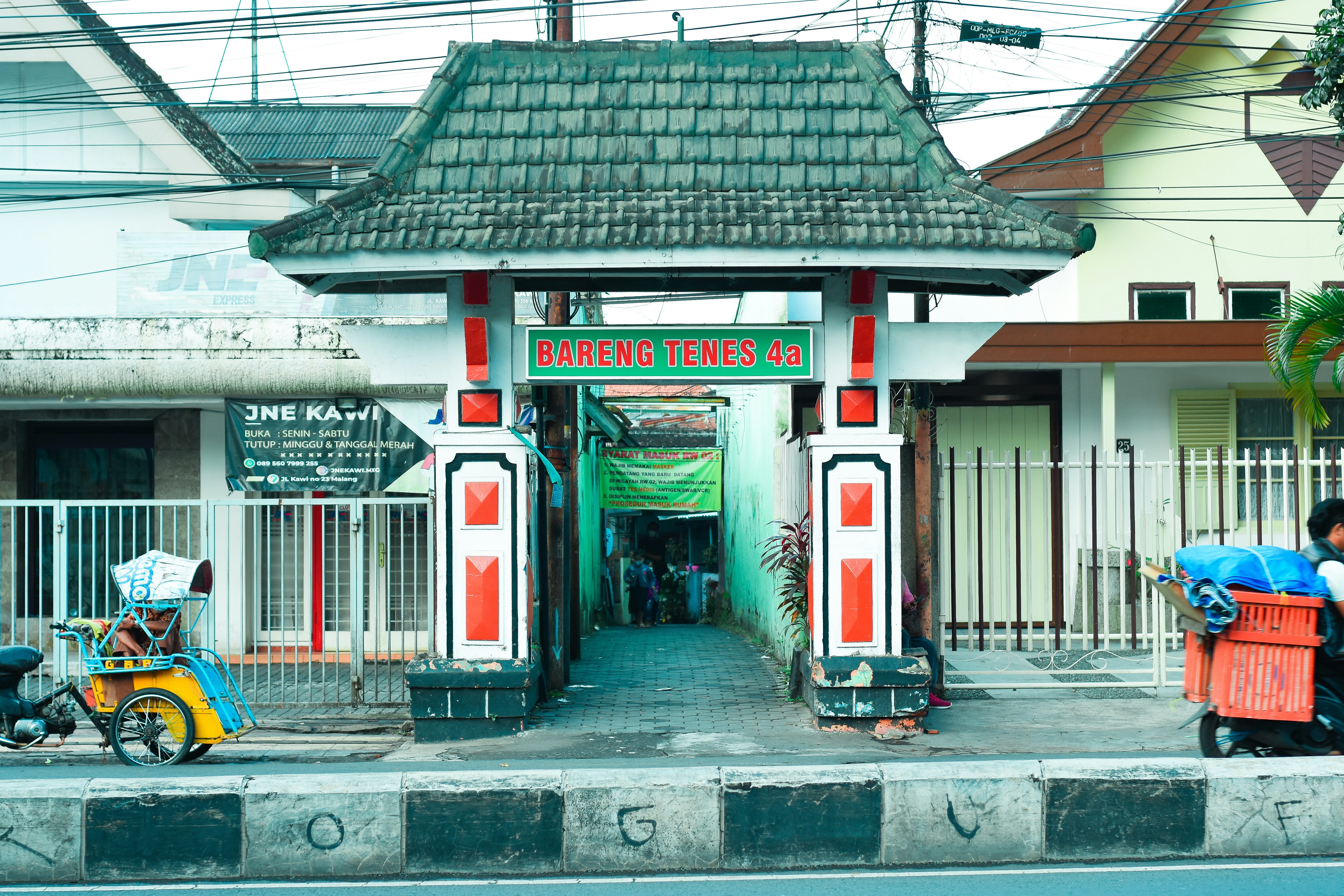 Seorang pria mendorong gerobak di jalan