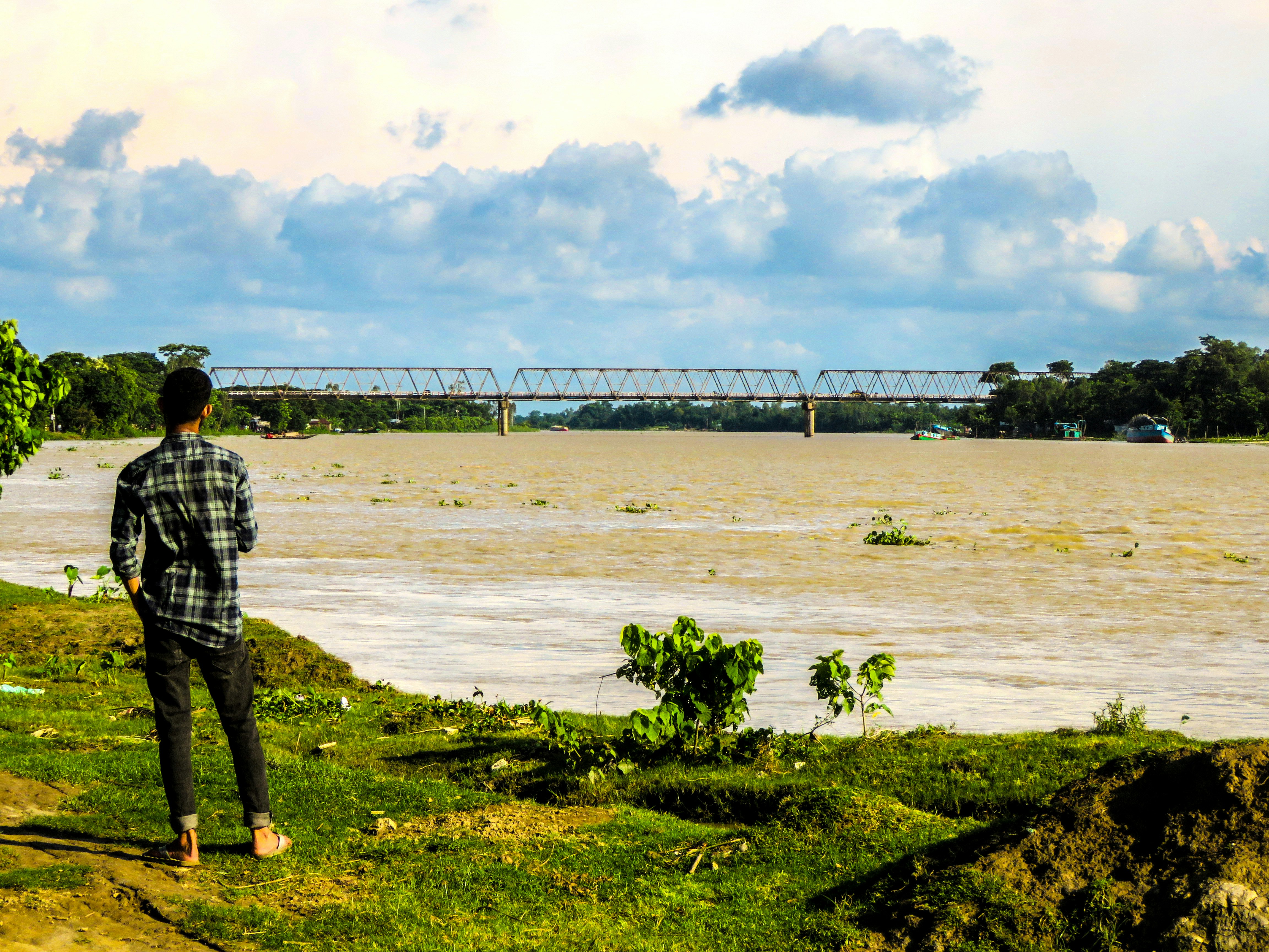 a man standing on a hill next to a body of water