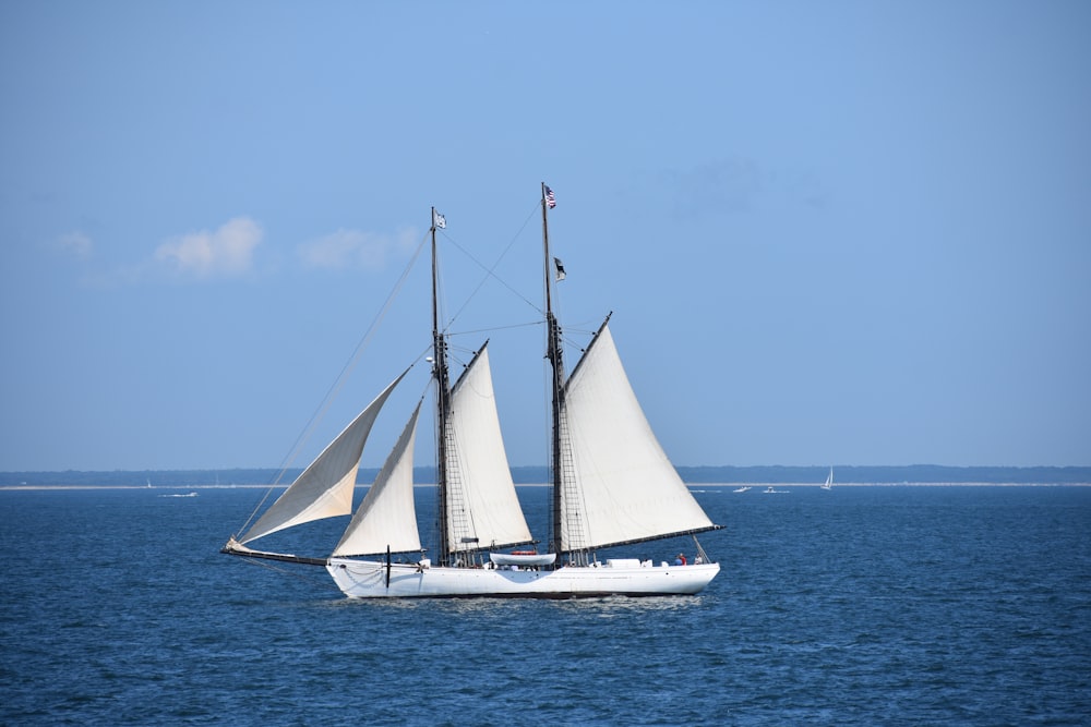 a sailboat sailing in the ocean on a sunny day