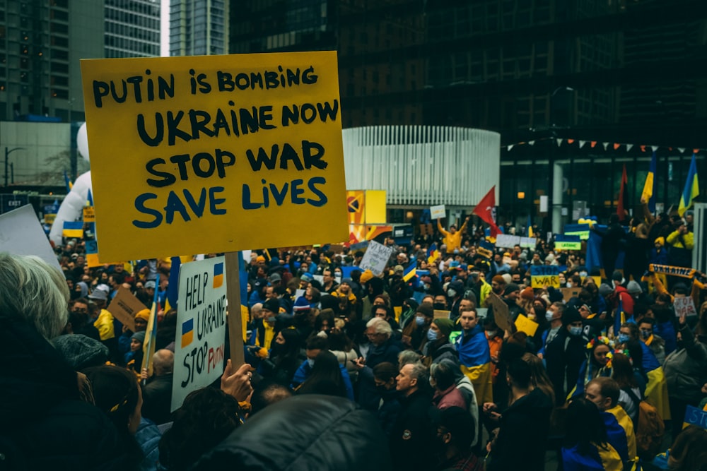 a large crowd of people holding signs and flags