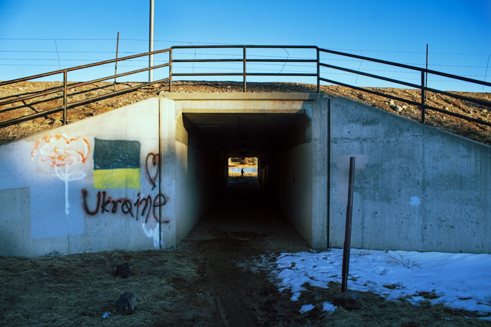 a tunnel with graffiti on the side of it