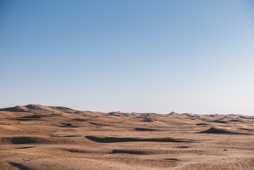 a view of a desert with sand dunes and a clear blue sky