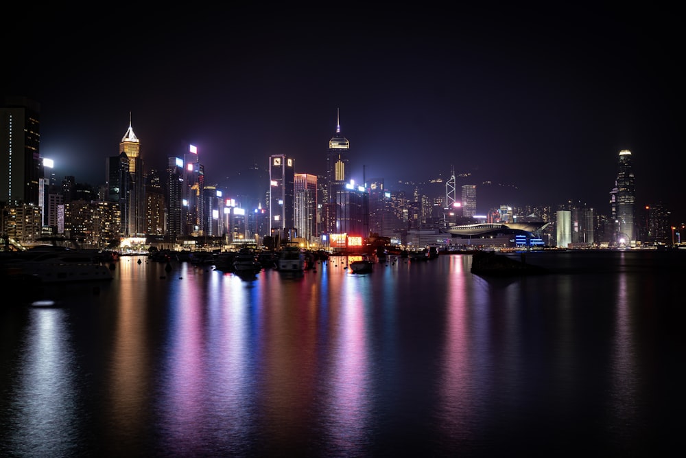 a city at night with lights reflecting in the water