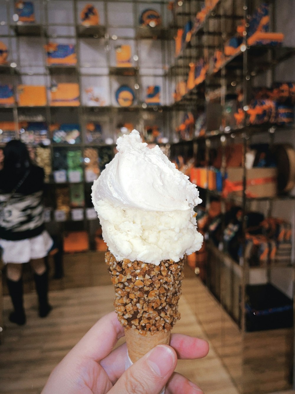 a person holding up an ice cream cone in a store