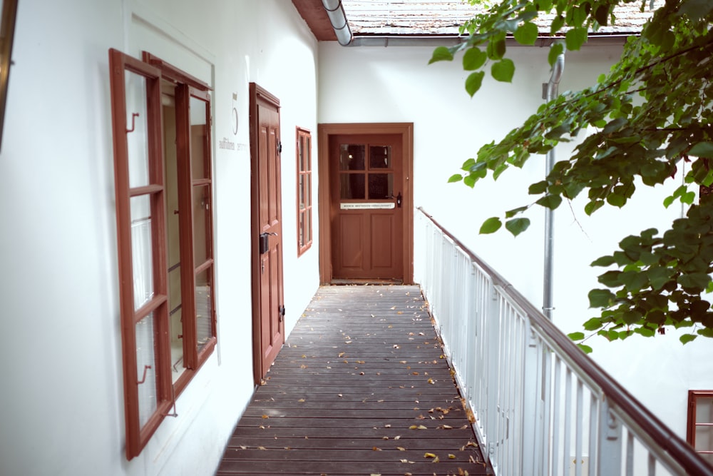 a wooden walkway leading to a door and window