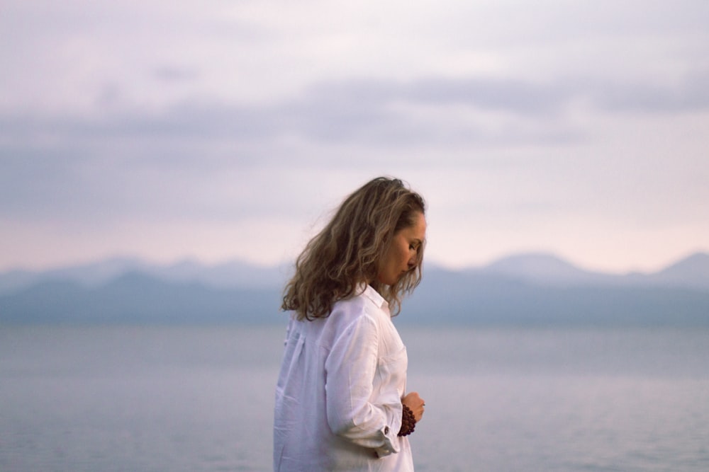 a woman standing on a beach next to the ocean