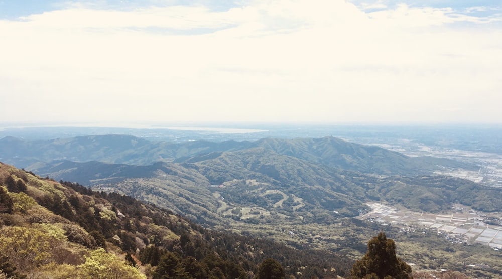 a view of a valley and mountains from the top of a hill