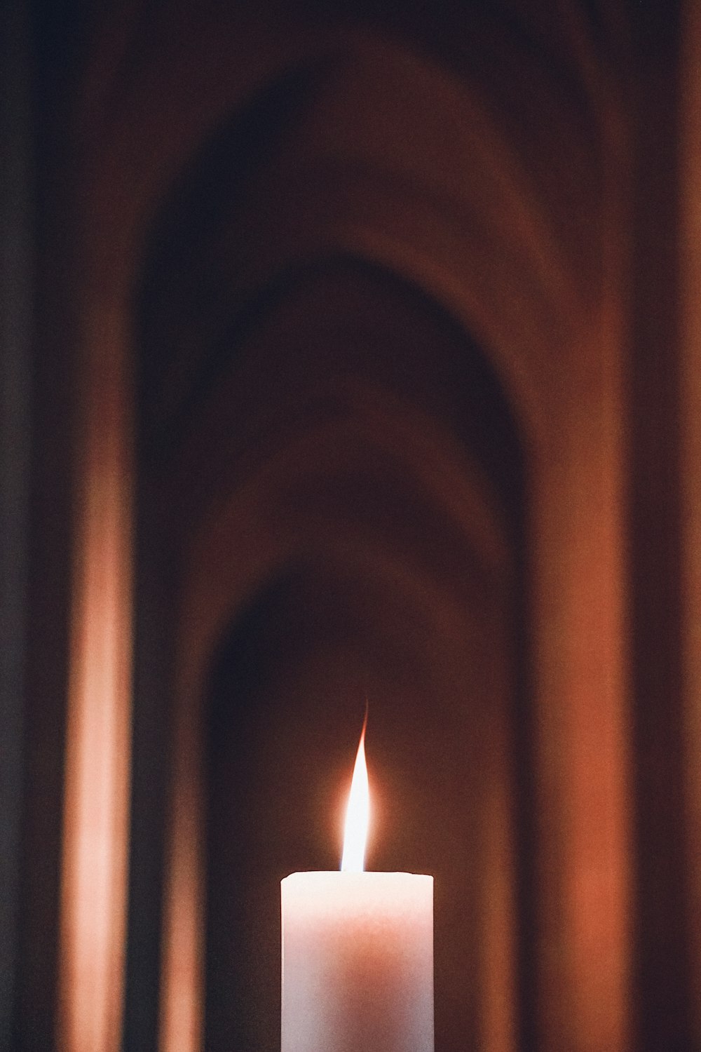 a white candle is lit in a dark room