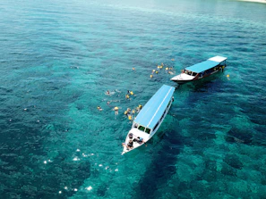 Guests enjoying water sports activities like jet-skiing and snorkeling in clear blue waters