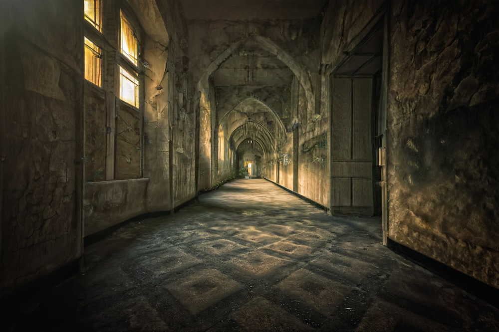 a dark hallway with light coming through the windows