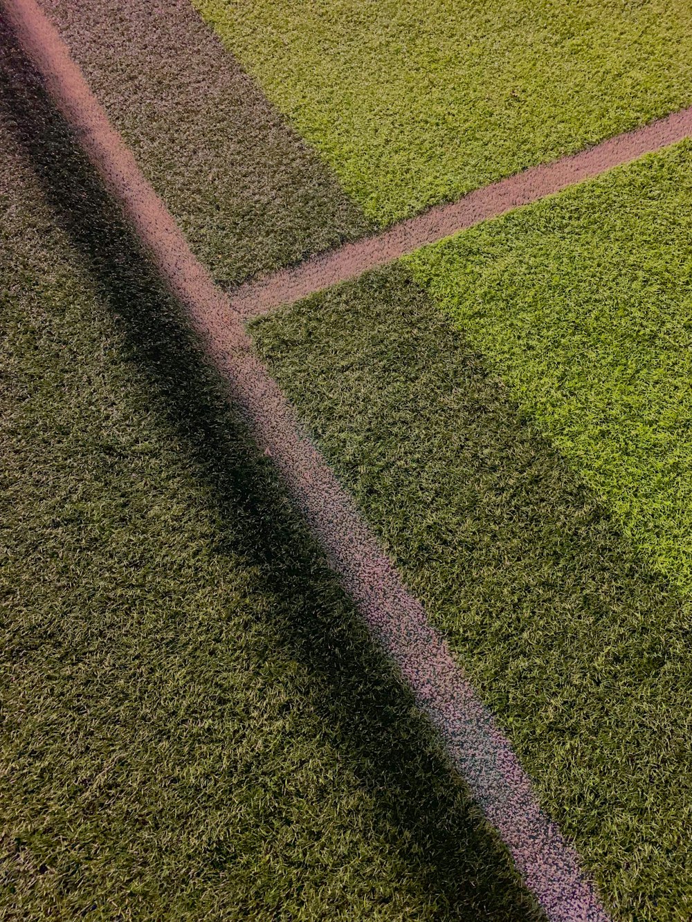 the shadow of a baseball bat on a baseball field