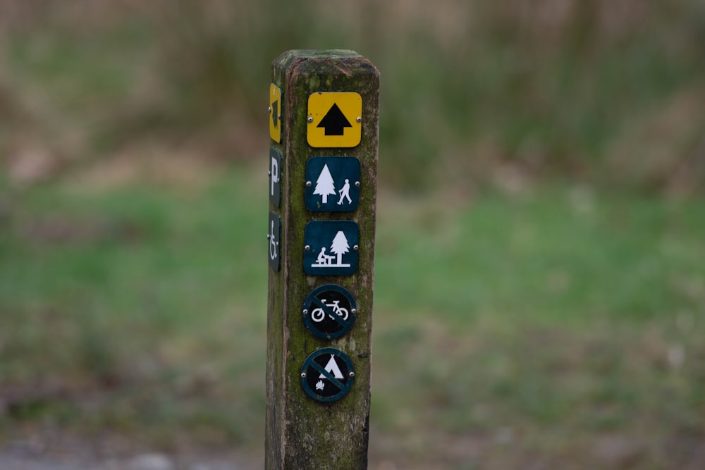 a wooden pole with a bunch of different signs on it