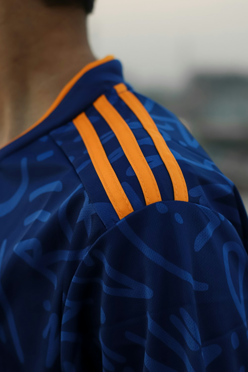 a close up of a person wearing a blue and orange uniform