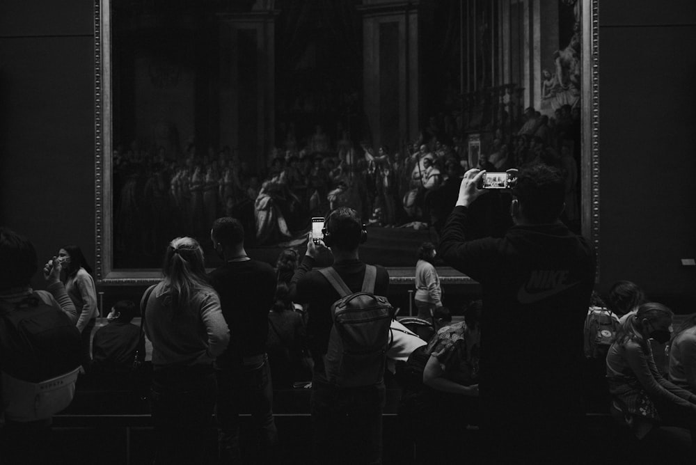 a group of people sitting in front of a painting