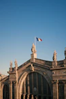 a building with statues and a flag on top of it