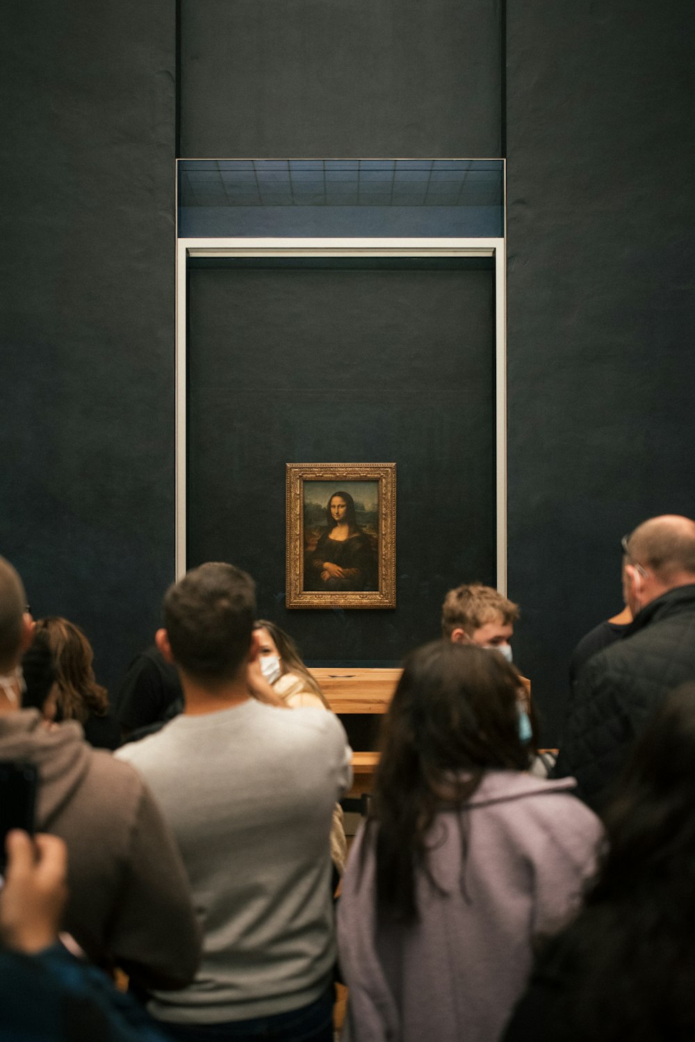 a group of people standing in front of a painting